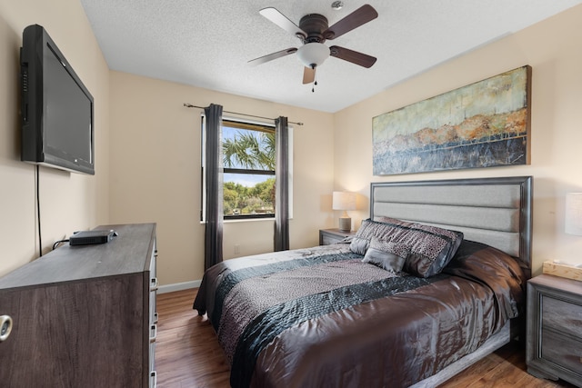bedroom featuring ceiling fan, baseboards, and wood finished floors