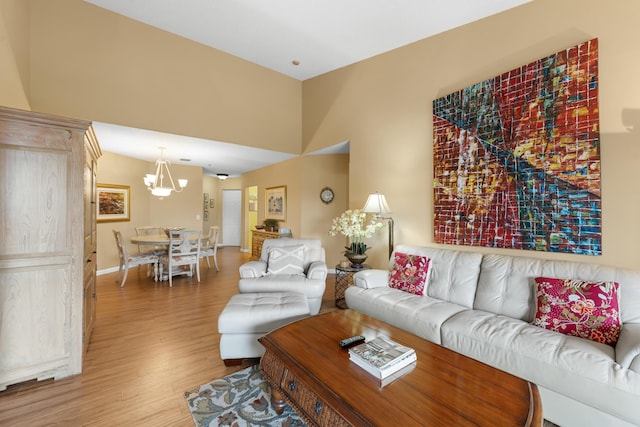 living area with light wood-style flooring, baseboards, and a chandelier