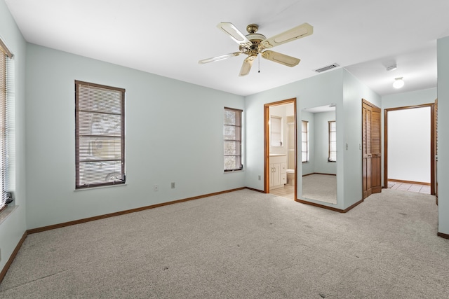 unfurnished bedroom with carpet floors, baseboards, ensuite bath, and visible vents