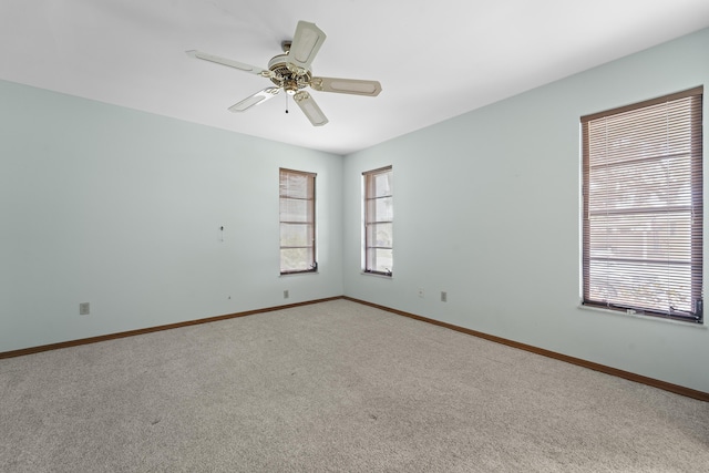 empty room featuring a ceiling fan, baseboards, and carpet