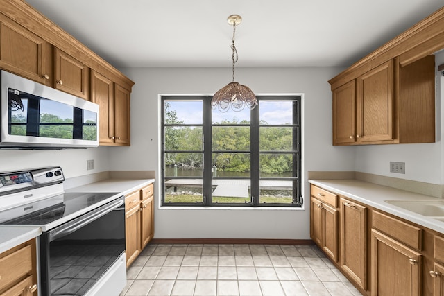 kitchen featuring light countertops, a chandelier, stainless steel microwave, and range with electric cooktop