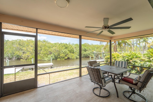 sunroom / solarium featuring a water view, a ceiling fan, and a wealth of natural light