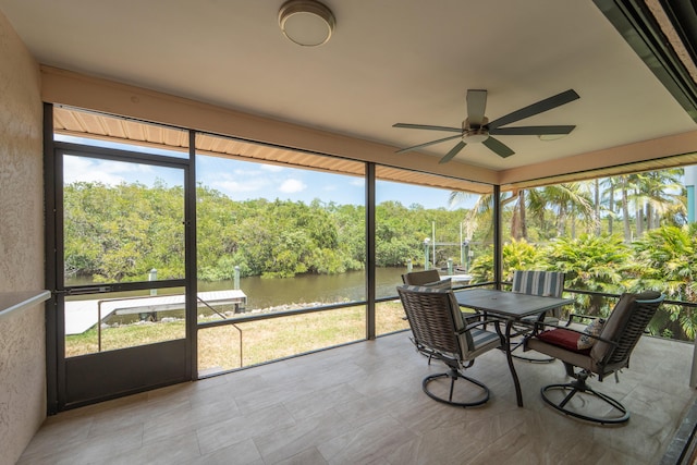 sunroom / solarium featuring outdoor dining space, a water view, and ceiling fan