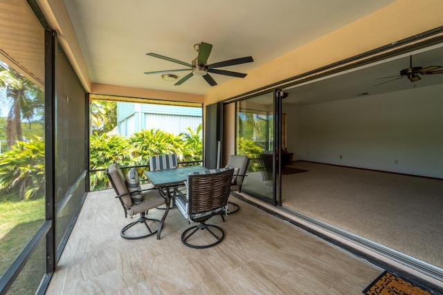 sunroom featuring a ceiling fan and outdoor dining space