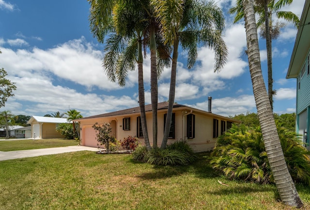 single story home with a garage, stucco siding, concrete driveway, and a front lawn