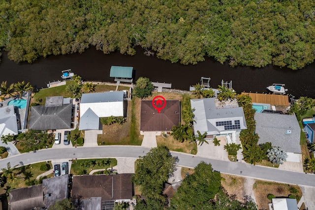 birds eye view of property with a water view and a wooded view