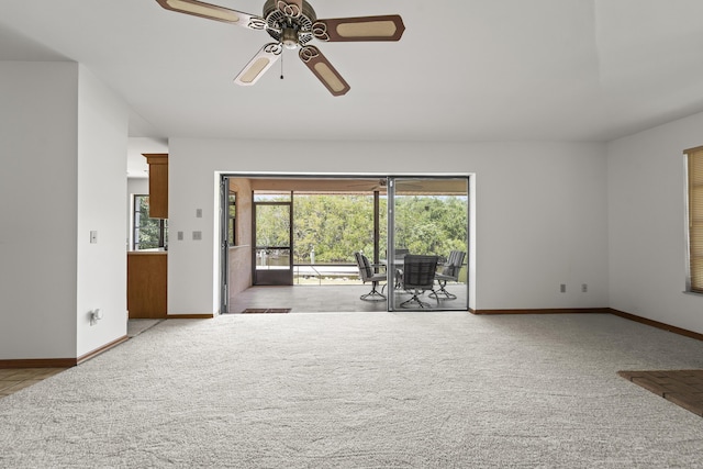 carpeted living area featuring baseboards and ceiling fan