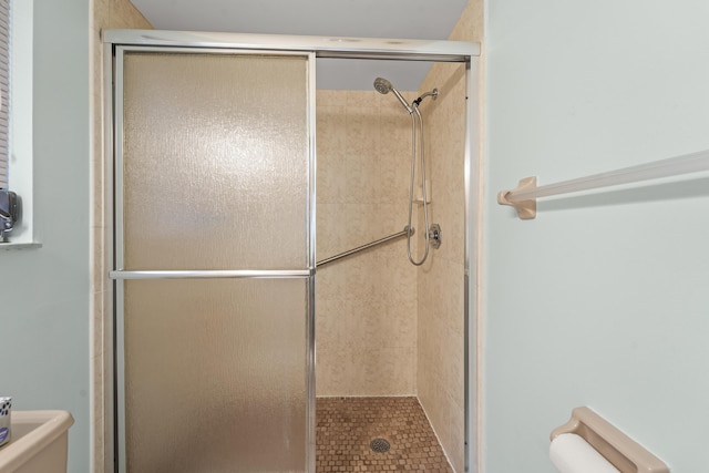 full bath with a stall shower and toilet