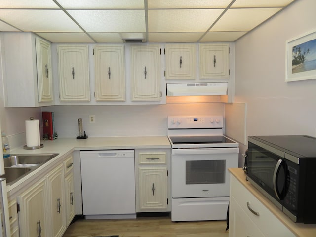 701 Lori Dr Unit 103, Palm Springs, FL 33461 - kitchen with white appliances, under cabinet range hood, a drop ceiling, light countertops, and light wood-style floors