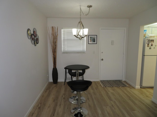 701 Lori Dr Unit 103, Palm Springs, FL 33461 - dining area with a chandelier, light wood-style floors, and baseboards