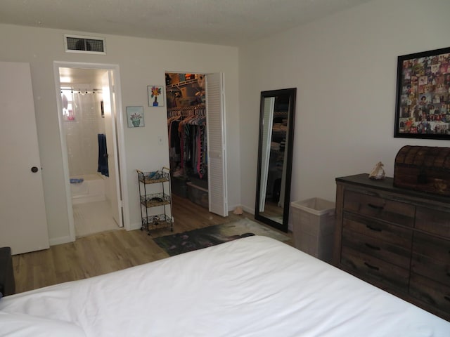 701 Lori Dr Unit 103, Palm Springs, FL 33461 - bedroom featuring wood finished floors, ensuite bath, a closet, and a spacious closet