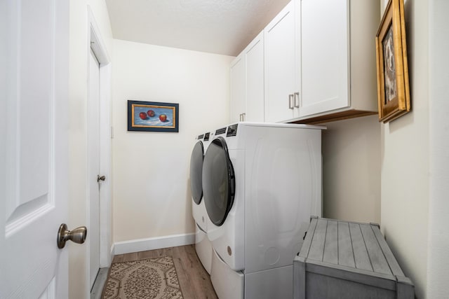 325 53rd Cir, Vero Beach, FL 32968 - clothes washing area with washing machine and clothes dryer, cabinet space, light wood finished floors, and baseboards