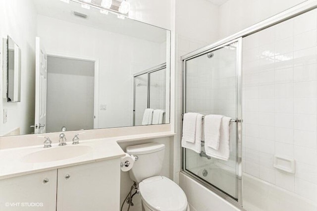 full bath featuring visible vents, bath / shower combo with glass door, toilet, and vanity