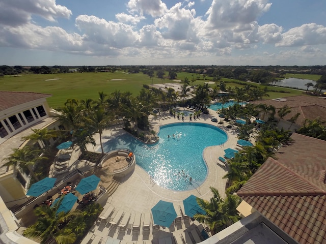 community pool with a water view and view of golf course