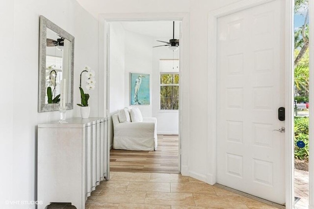 foyer entrance featuring baseboards, plenty of natural light, and ceiling fan