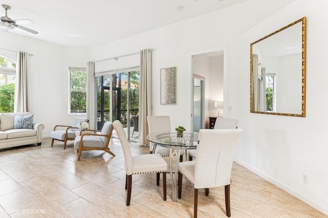dining area with a ceiling fan and baseboards