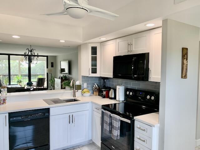 6562 Boca Del Mar Dr Unit 527, Boca Raton, FL 33433 - kitchen with black appliances, a sink, tasteful backsplash, white cabinets, and a ceiling fan