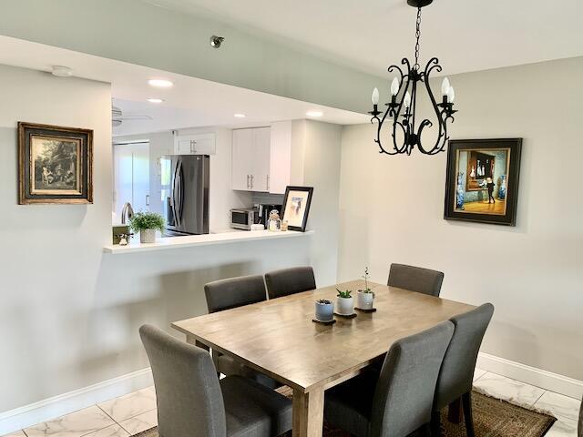 6562 Boca Del Mar Dr Unit 527, Boca Raton, FL 33433 - dining space featuring light marble finish flooring, baseboards, a chandelier, and recessed lighting