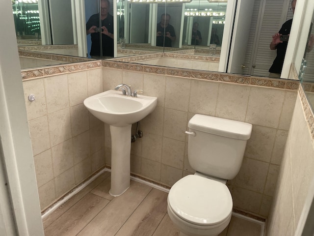 3589 S Ocean Blvd Unit 509, South Palm Beach, FL 33480 - bathroom featuring toilet, wood finished floors, and tile walls