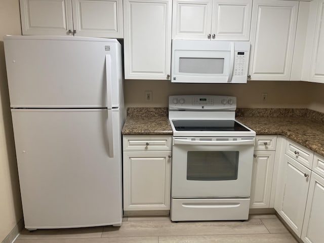3589 S Ocean Blvd Unit 509, South Palm Beach, FL 33480 - kitchen featuring white appliances, white cabinetry, and dark stone countertops