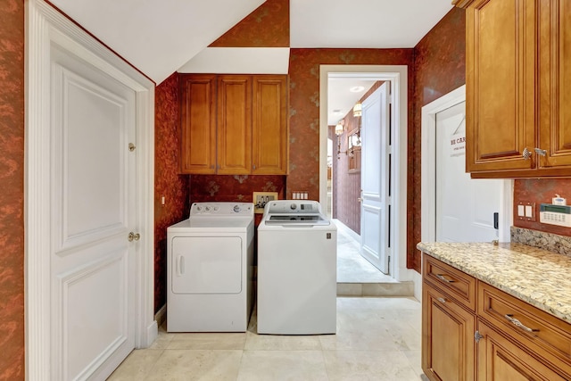 washroom featuring cabinet space, separate washer and dryer, and light tile patterned flooring