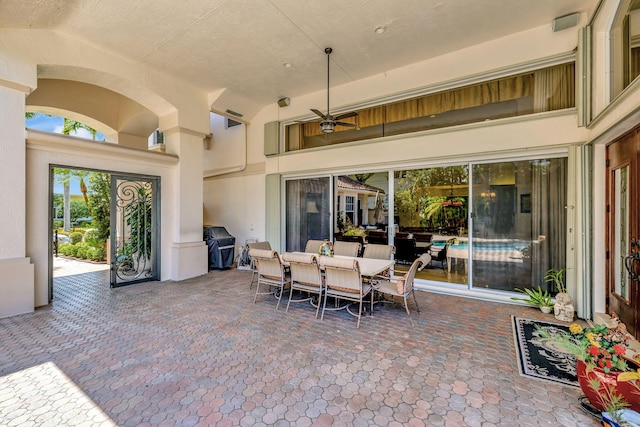 view of patio featuring a ceiling fan, outdoor dining space, and grilling area