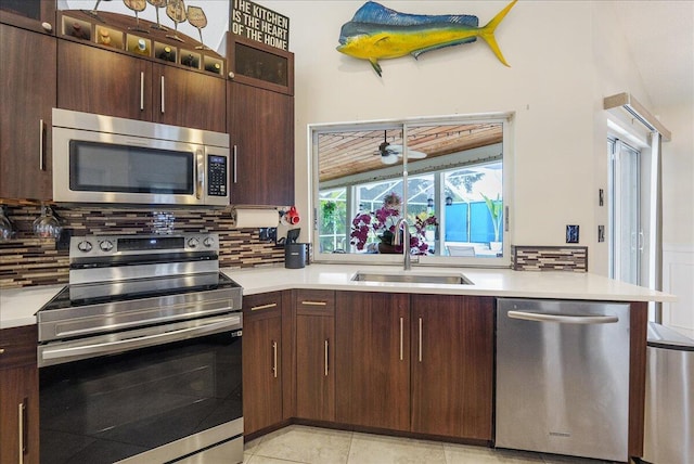 2266 SW Monterrey Ln, Port Saint Lucie, FL 34953 - kitchen featuring appliances with stainless steel finishes, a sink, tasteful backsplash, light countertops, and dark brown cabinetry