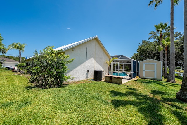 2266 SW Monterrey Ln, Port Saint Lucie, FL 34953 - view of green lawn with central air condition unit, glass enclosure, and an outdoor pool