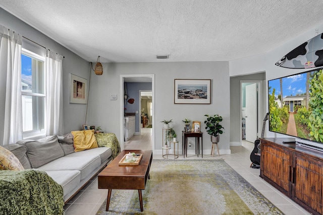 1008 SE 3rd St, Boynton Beach, FL 33435 - living room featuring light tile patterned flooring, a textured ceiling, and visible vents