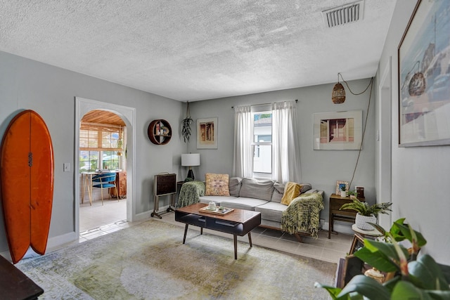 1008 SE 3rd St, Boynton Beach, FL 33435 - living area featuring tile patterned floors, visible vents, arched walkways, and a textured ceiling