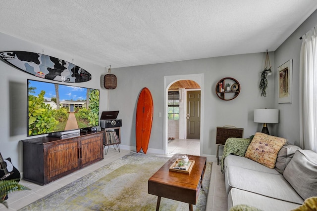 1008 SE 3rd St, Boynton Beach, FL 33435 - living area with arched walkways, a textured ceiling, and light tile patterned floors