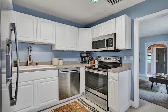 1008 SE 3rd St, Boynton Beach, FL 33435 - kitchen with white cabinets, appliances with stainless steel finishes, a sink, and light tile patterned floors
