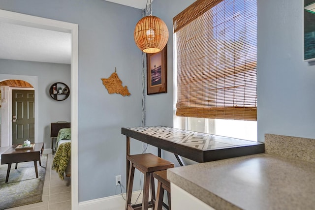 1008 SE 3rd St, Boynton Beach, FL 33435 - dining room featuring baseboards, arched walkways, and light tile patterned floors