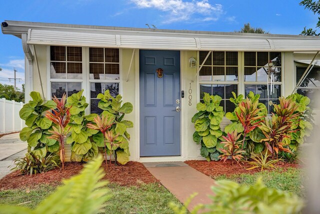 1008 SE 3rd St, Boynton Beach, FL 33435 - view of exterior entry featuring stucco siding and fence