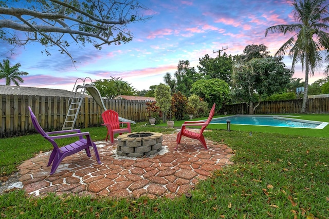 5340 SW 115th Ave, Cooper City, FL 33330 - patio terrace at dusk with a lawn, a fire pit, a fenced in pool, and a fenced backyard