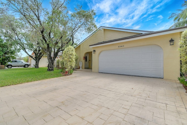 5340 SW 115th Ave, Cooper City, FL 33330 - view of front of home featuring stucco siding, a front yard, decorative driveway, and a garage