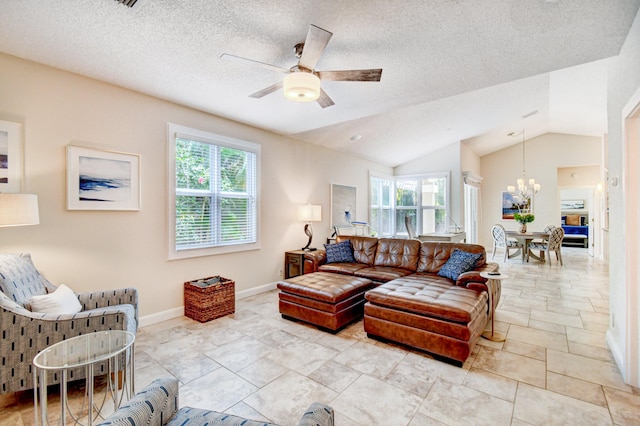 living area featuring ceiling fan with notable chandelier, vaulted ceiling, baseboards, and a wealth of natural light