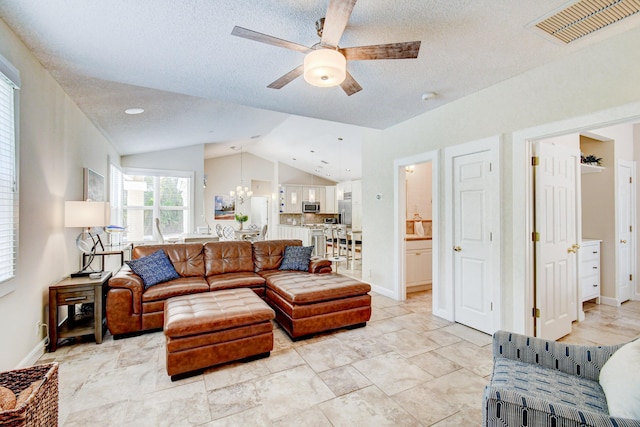 living area featuring a textured ceiling, vaulted ceiling, visible vents, and ceiling fan with notable chandelier