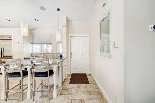 17586 Tiffany Trace Dr, Boca Raton, FL 33487 - kitchen with white cabinetry, built in refrigerator, light countertops, a breakfast bar, and a peninsula