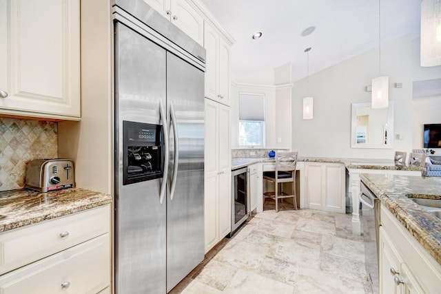 kitchen with vaulted ceiling, decorative backsplash, beverage cooler, appliances with stainless steel finishes, and light stone countertops