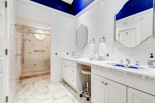 bathroom with tile walls, a sink, double vanity, and a stall shower