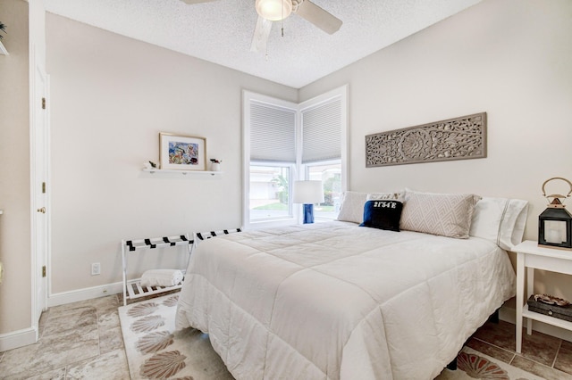 bedroom featuring a textured ceiling, a ceiling fan, and baseboards