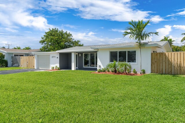 2771 NE 53rd St, Lighthouse Point, FL 33064 - ranch-style house with a front lawn, driveway, an attached garage, fence, and stucco siding