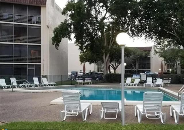 community pool with fence and a patio