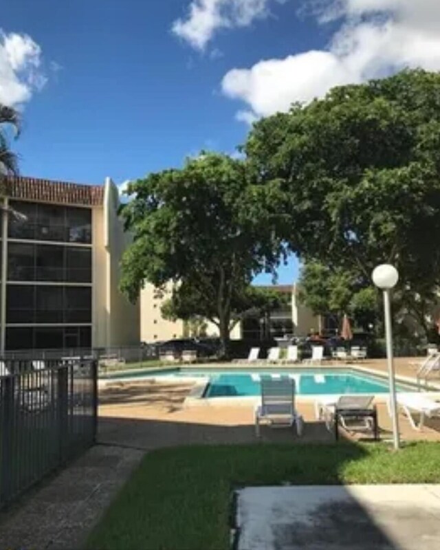 pool featuring fence and a patio area