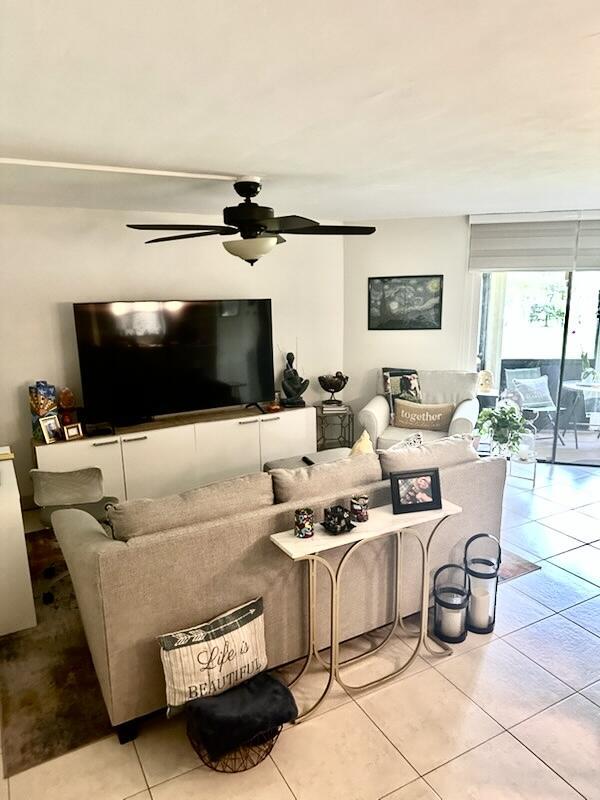 living room with a ceiling fan and tile patterned flooring
