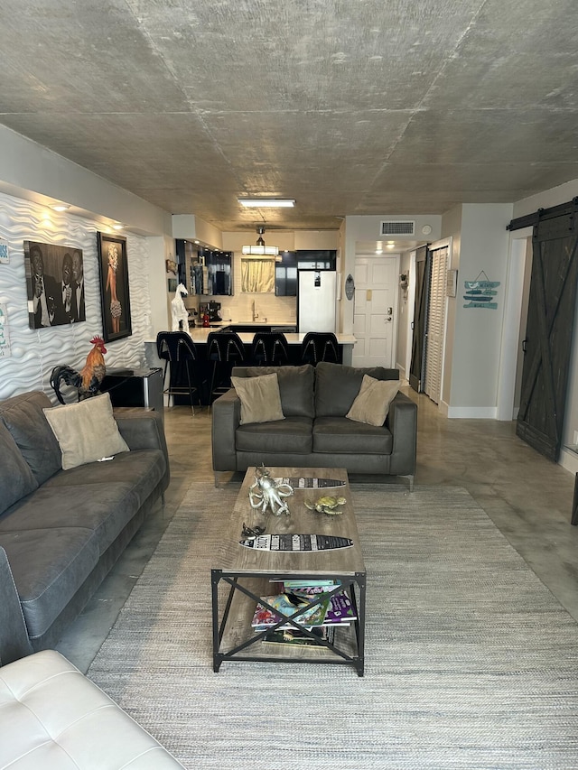 3570 S Ocean Blvd Unit 205, South Palm Beach, FL 33480 - living room featuring visible vents, finished concrete floors, and a barn door