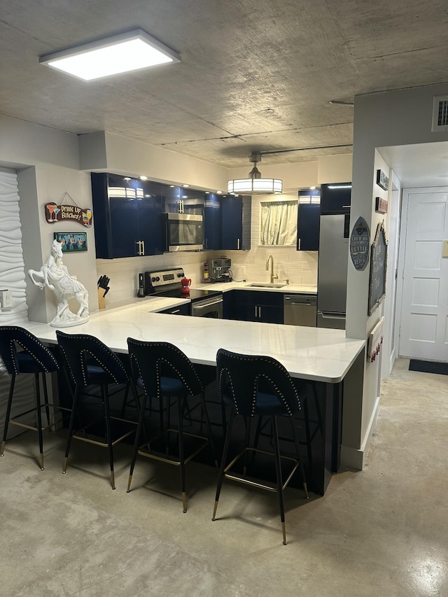 3570 S Ocean Blvd Unit 205, South Palm Beach, FL 33480 - kitchen with a peninsula, a sink, a kitchen bar, light countertops, and appliances with stainless steel finishes