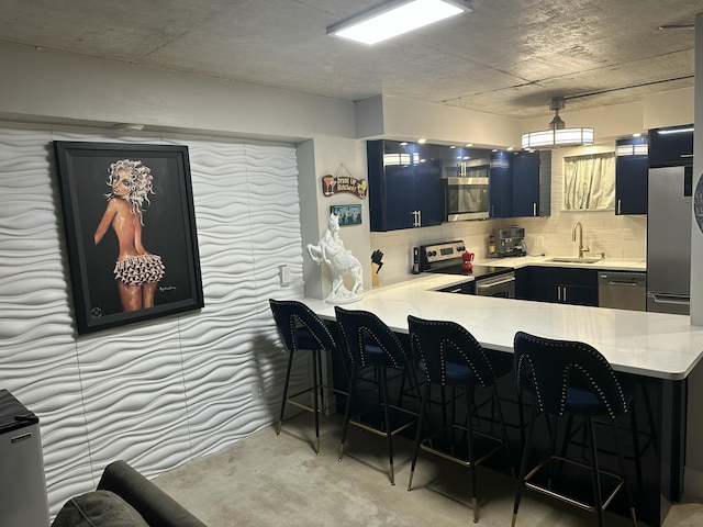 3570 S Ocean Blvd Unit 205, South Palm Beach, FL 33480 - kitchen featuring blue cabinets, stainless steel appliances, a kitchen breakfast bar, a sink, and light countertops