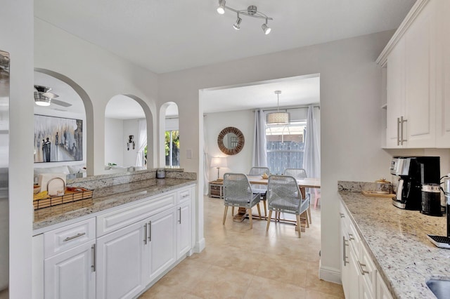 1275 Waterway Cove Dr, Wellington, FL 33414 - kitchen featuring light stone countertops, decorative light fixtures, and white cabinetry
